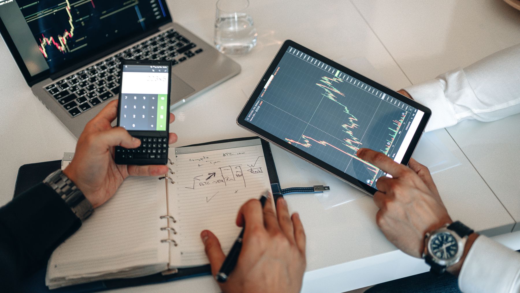 Financial analysis with calculator, tablet and charts